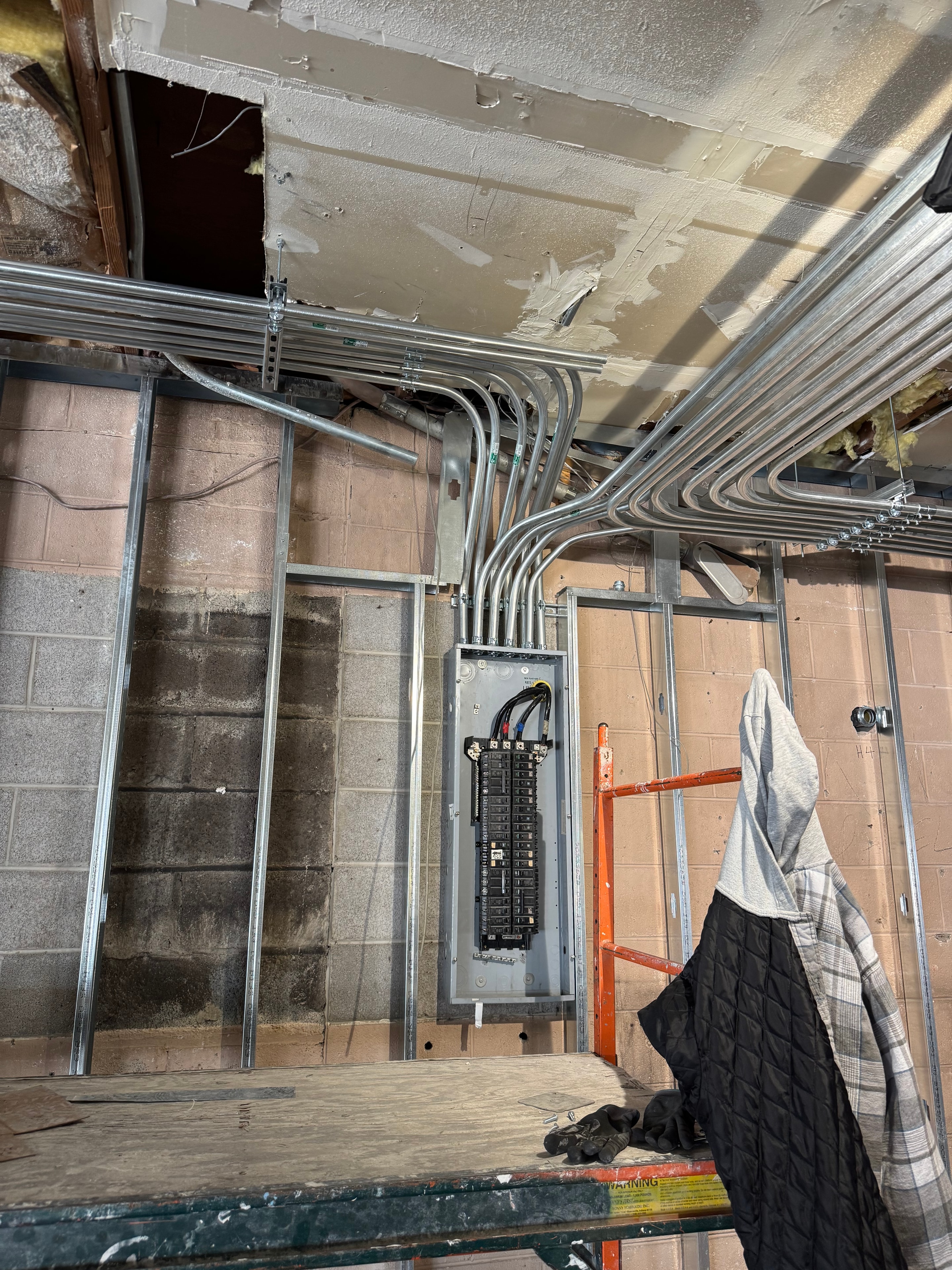 New electrical panel and conduit installation during a commercial gym build-out